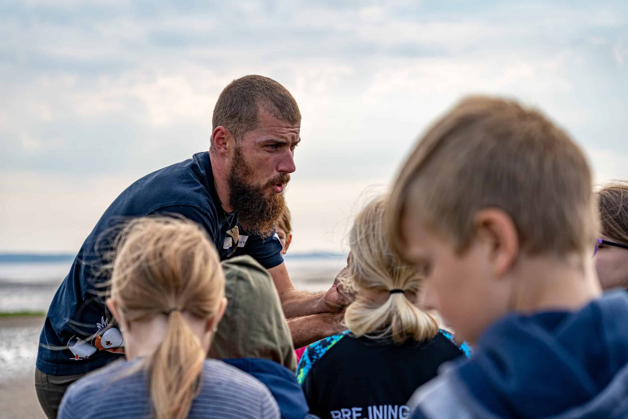 a person with a beard and a group of kids