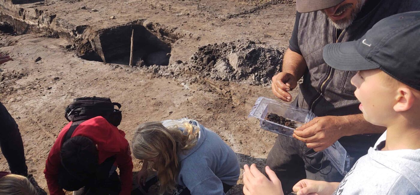 A group of people gathered around a hole, possibly engaged in a discussion or observing something.